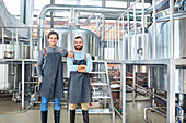 Male brewers in aprons near vats