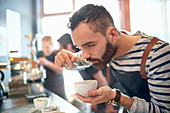 Male coffee roaster tasting coffee