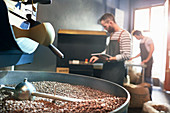 Male coffee roasters behind roasting coffee beans