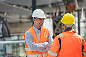 Smiling foreman talking to construction worker