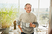 Smiling mature man drinking coffee house sun porch