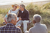Senior couples drinking coffee on beach