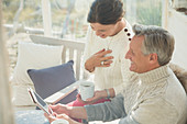 Mature couple using tablet on porch