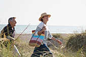 Mature couple with fishing rod walking