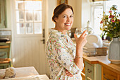 Portrait mature woman drinking wine in kitchen