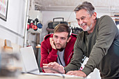 Male carpenters working at laptop