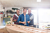 Portrait male carpenters working at wood boat