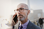 Close up serious businessman talking on cell phone