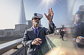 Businessman using VR glasses, London, UK