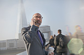 Businessman talking on cell phone, London, UK