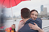 Couple with umbrella hugging, London, UK