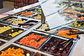 Salad bar items and tongs in market