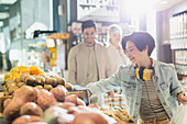 Young woman, browsing produce in market