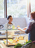 Woman helping customer at cheese counter