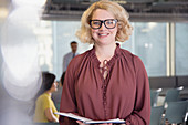 Portrait businesswoman with paperwork in office