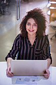 Portrait businesswoman working at laptop
