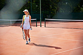 Young tennis player walking