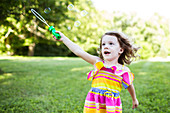 Preschool girl playing with bubble wand