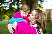 Affectionate mother holding son wrapped in a towel