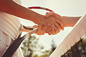 Close up tennis players handshaking at net