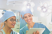 Female surgeons using digital tablet, talking