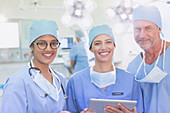 Portrait smiling surgeons using digital tablet