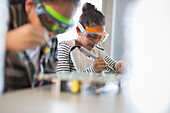 Focused girl students soldering circuit boards