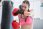 Young boxer biting, removing boxing gloves
