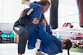 Determined women practicing jiu-jitsu in gym