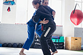 Women practicing jiu-jitsu in gym