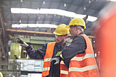 Male workers talking in factory