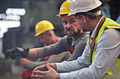 Male workers talking in factory