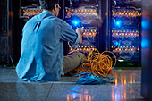 Male IT technician with cables at panel