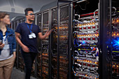 IT technicians walking along panels in server room