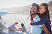 Smiling, father piggybacking daughter