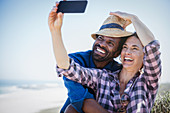 Playful couple taking selfie with camera phone