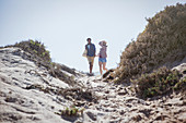 Couple walking on sunny summer beach path