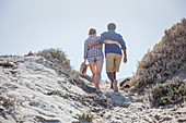 Affectionate couple walking up summer beach path