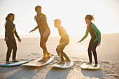 Family surfers practicing on surfboards