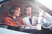 Pilot talking to in passenger in airplane cockpit