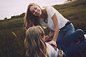 Playful teenage sisters in rural field