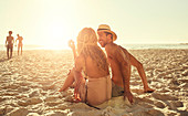 Young couple relaxing on sunny summer beach