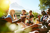 Young friends hanging out, enjoying picnic in park