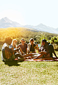 Young friends enjoying picnic in grass