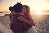 Affectionate couple hugging on sunset summer beach