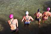 Overhead view female swimmers wading in ocean