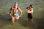 Laughing female swimmers wading