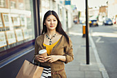Young woman walking along storefront