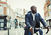 African businessman commuting, riding bicycle