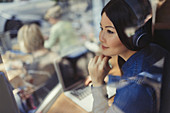 Pensive woman at laptop listening to music